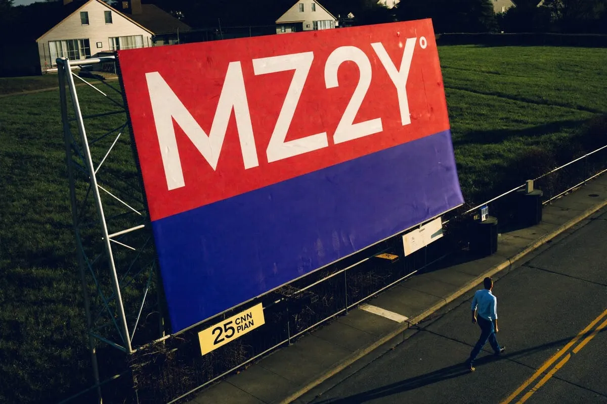 Groot rood-blauw billboard met tekst 'MZ2Y', voorbijganger loopt op straat ernaast