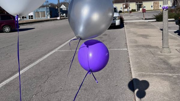 Silver and blue balloons on sidewalk