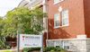 The photo shows the front entrance of Woodland Christian Church. The red-brick building has columns and trees out front. A sign says "Welcome Home!"