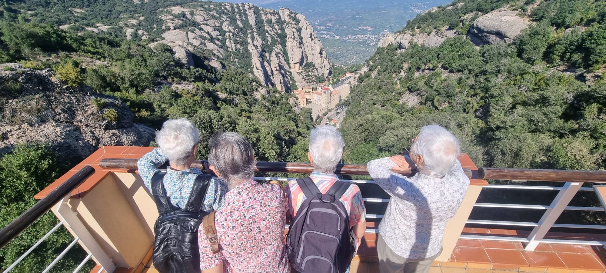 cuatro adultos mayores disfrutando de una vista panorámica en un mirador.