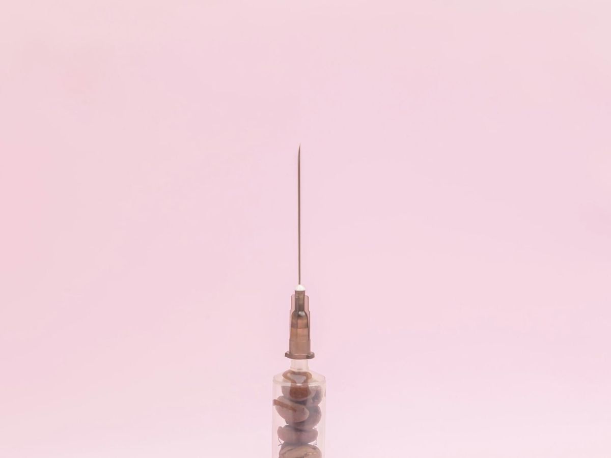 Close-up of a syringe and needle, illustrating the tools involved in non-surgical facial rejuvenation treatments.