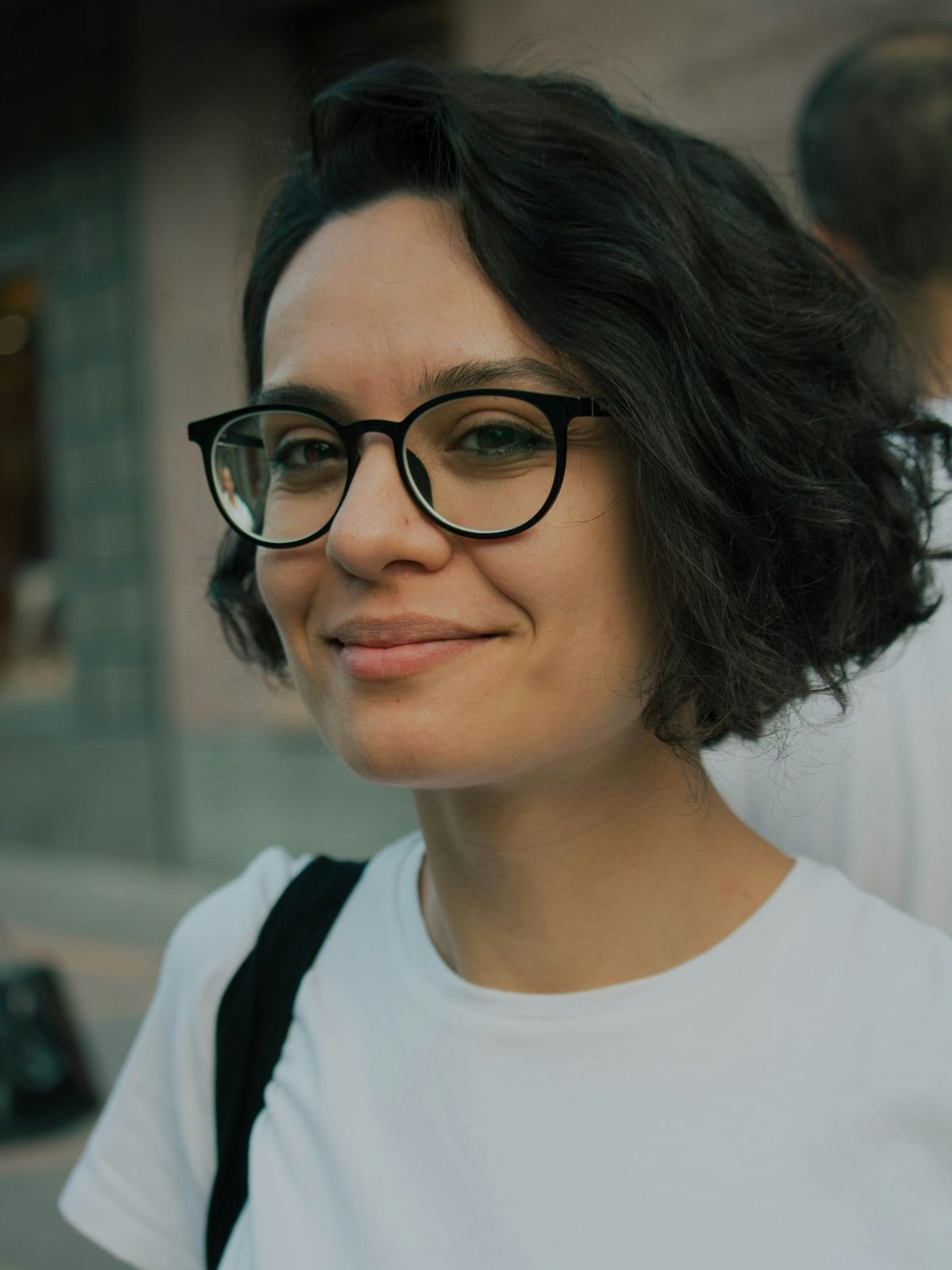 Confident woman smiling with natural crow's feet, demonstrating how subtle aesthetic treatments can soften stress lines while preserving genuine expression.