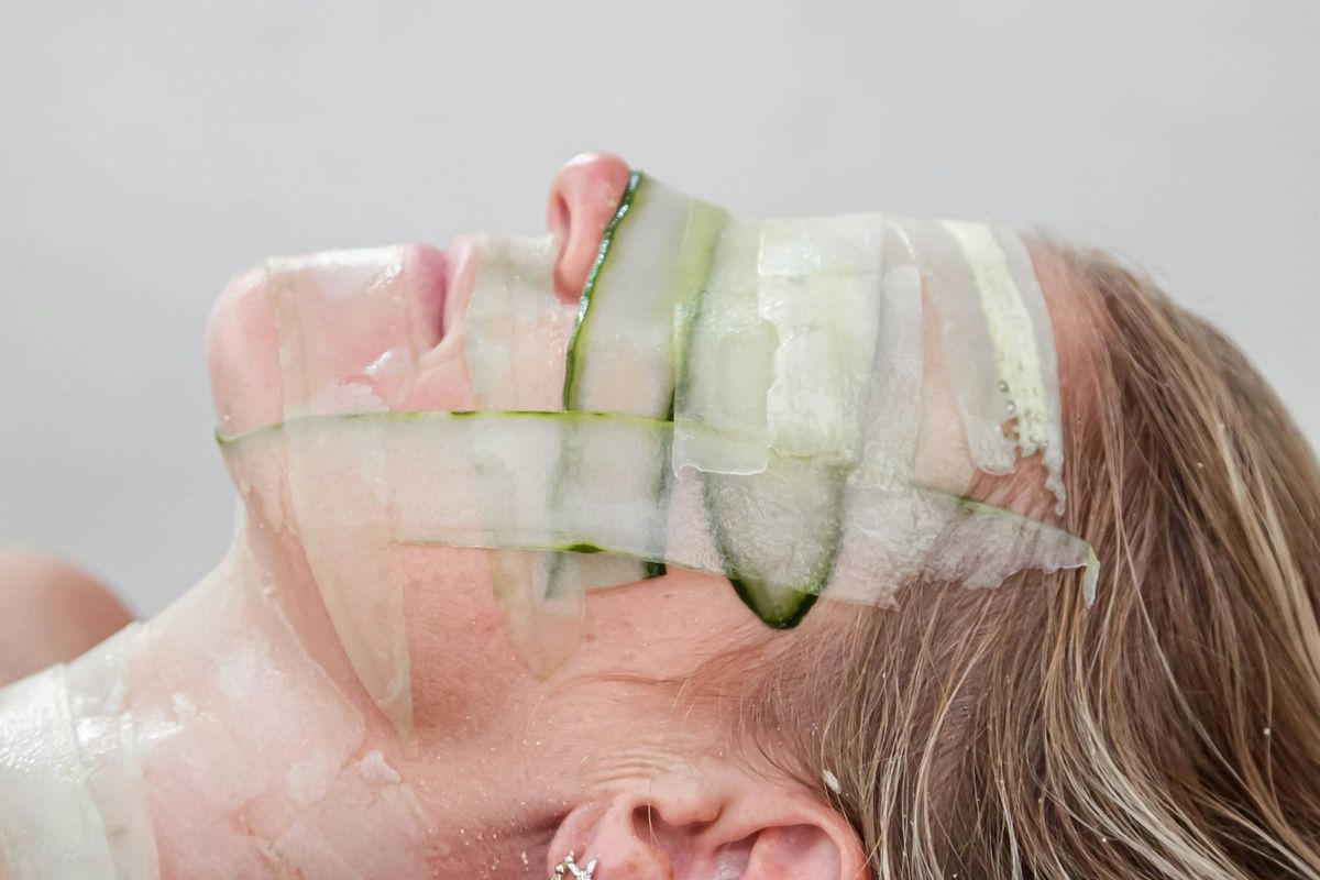 Woman with cucumber strips on her face, symbolizing natural and soothing skincare treatments to refresh and rejuvenate healthy skin.