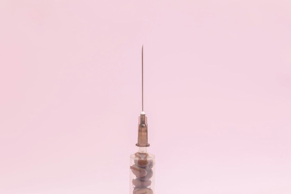 Close-up of a syringe and needle, illustrating the tools involved in non-surgical facial rejuvenation treatments.