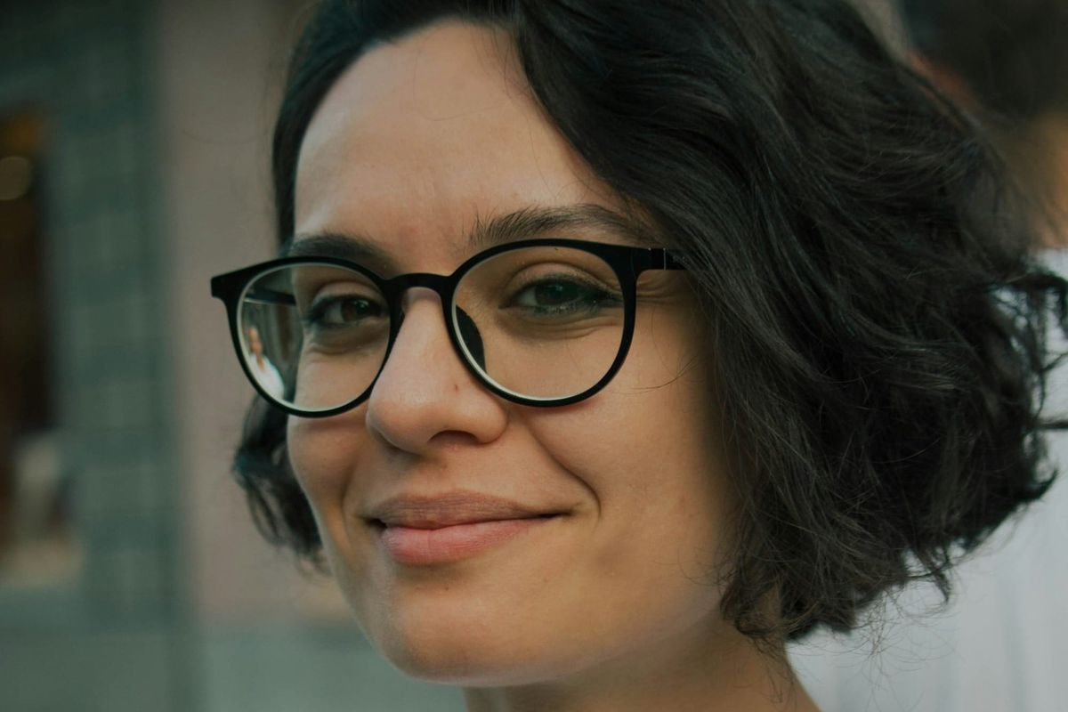 Confident woman smiling with natural crow's feet, demonstrating how subtle aesthetic treatments can soften stress lines while preserving genuine expression.