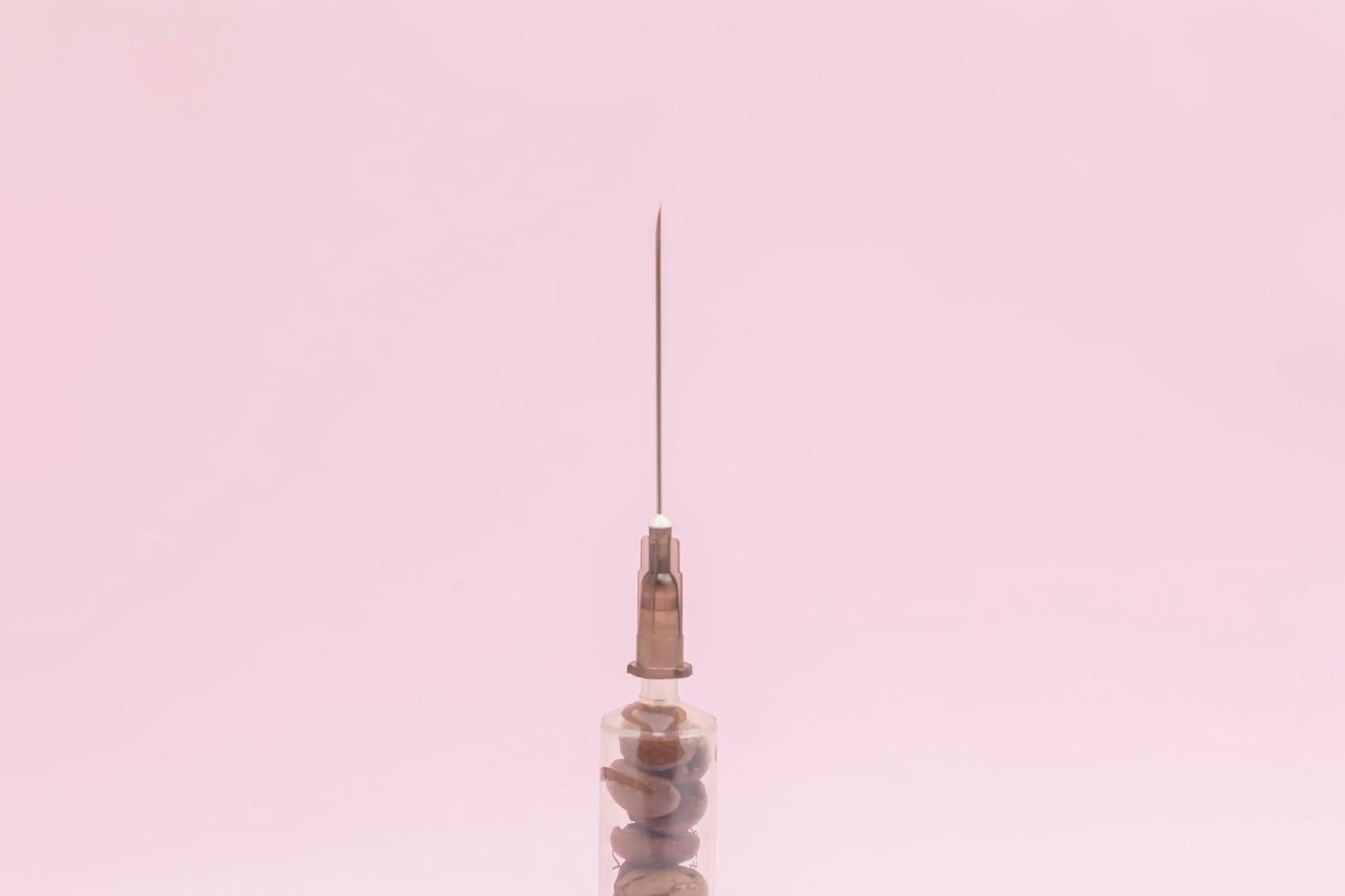 Close-up of a syringe and needle, illustrating the tools involved in non-surgical facial rejuvenation treatments.