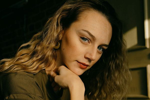 Woman resting her chin on her hand, illustrating well lifted facial contours and jawline