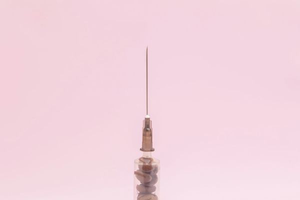 Close-up of a syringe and needle, illustrating the tools involved in non-surgical facial rejuvenation treatments.