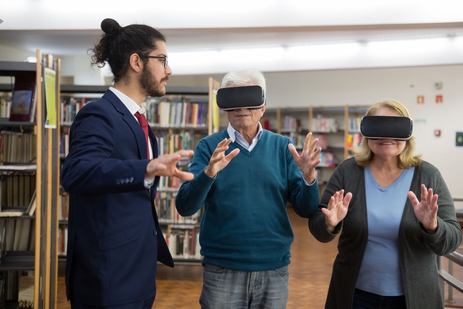 Elderly couple experiencing virtual reality in a modern library setting.