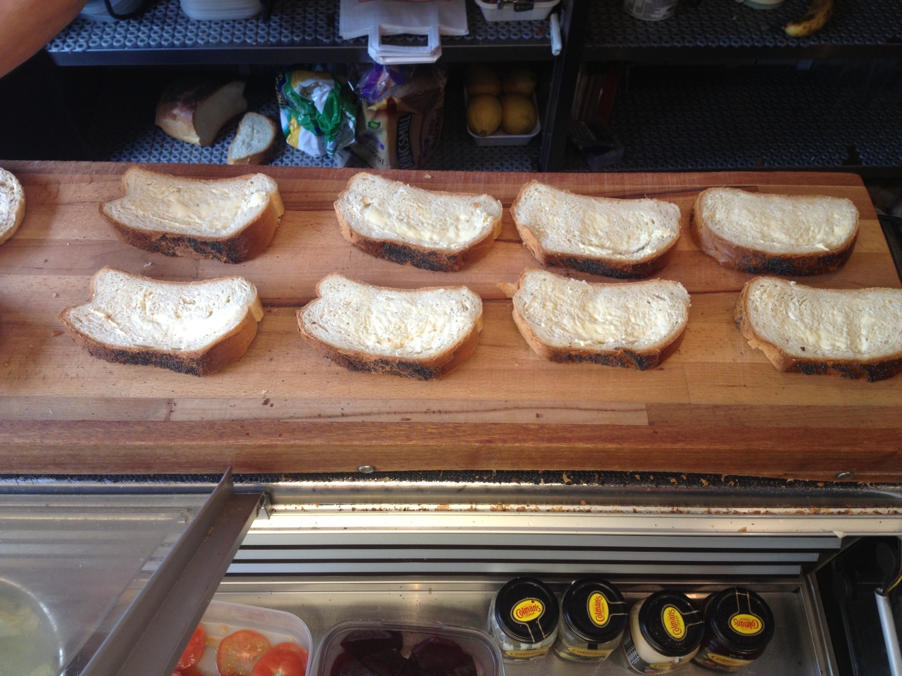 8 slices of white bread buttered and waiting on the counter. 