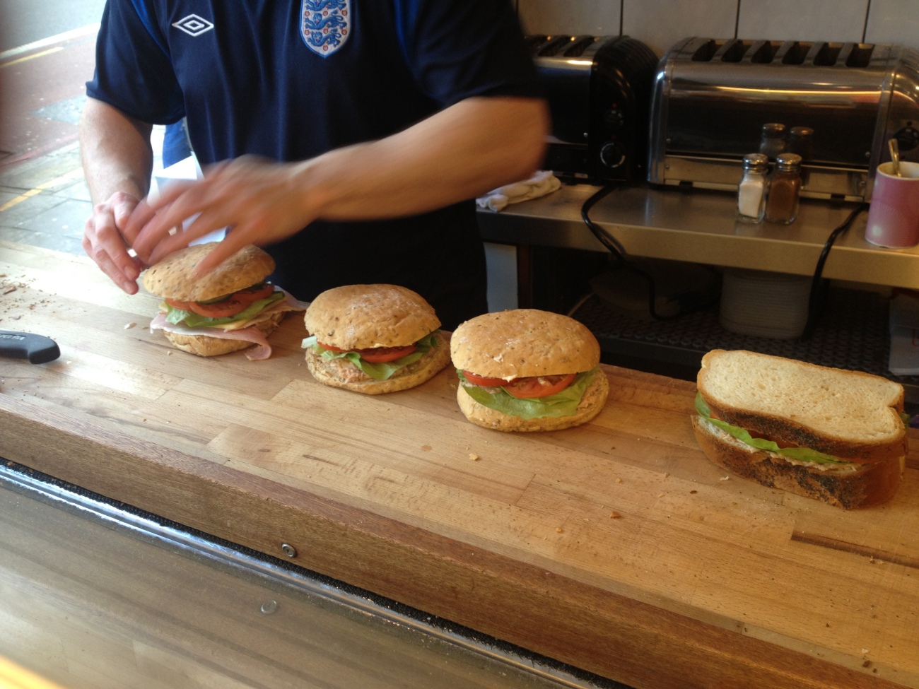 James closes up the sandwiches and pops their tops on. 