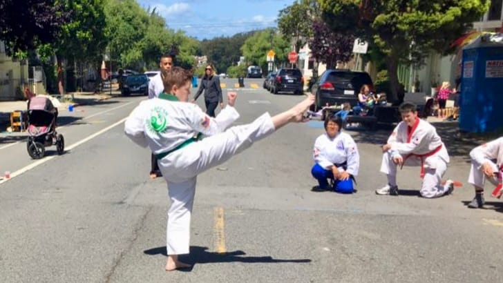 martial artist demonstrating a front kick, foot pointed, toes pulled back
