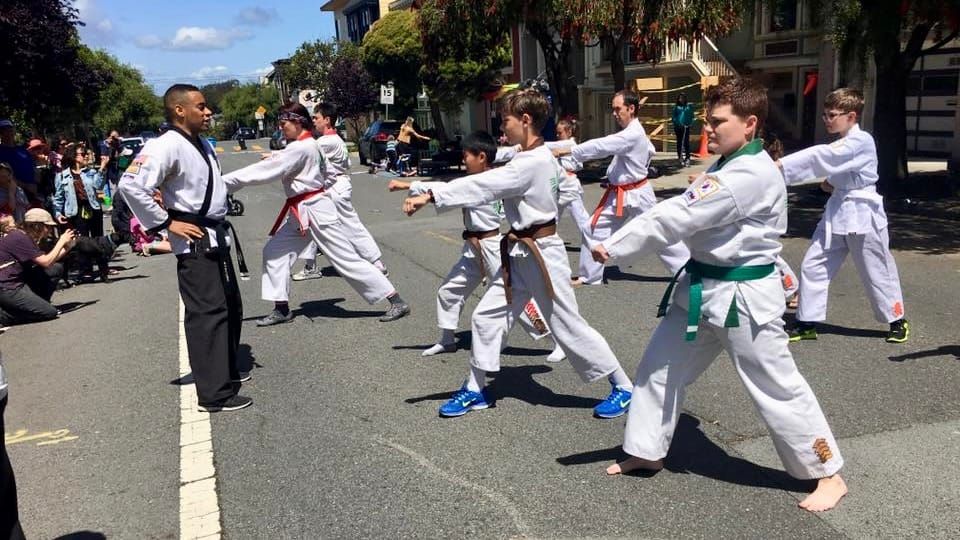 martial artists performing at a 6th ave neighborhood block party