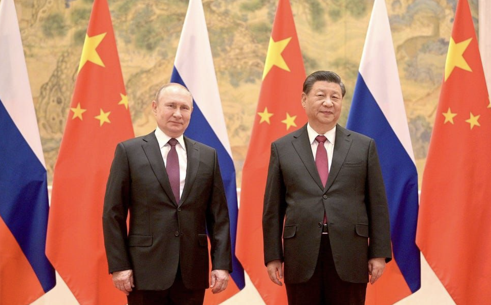 Putin and Xi pose in front of flags during a meeting in Beijing ahead of the 2022 Olympics