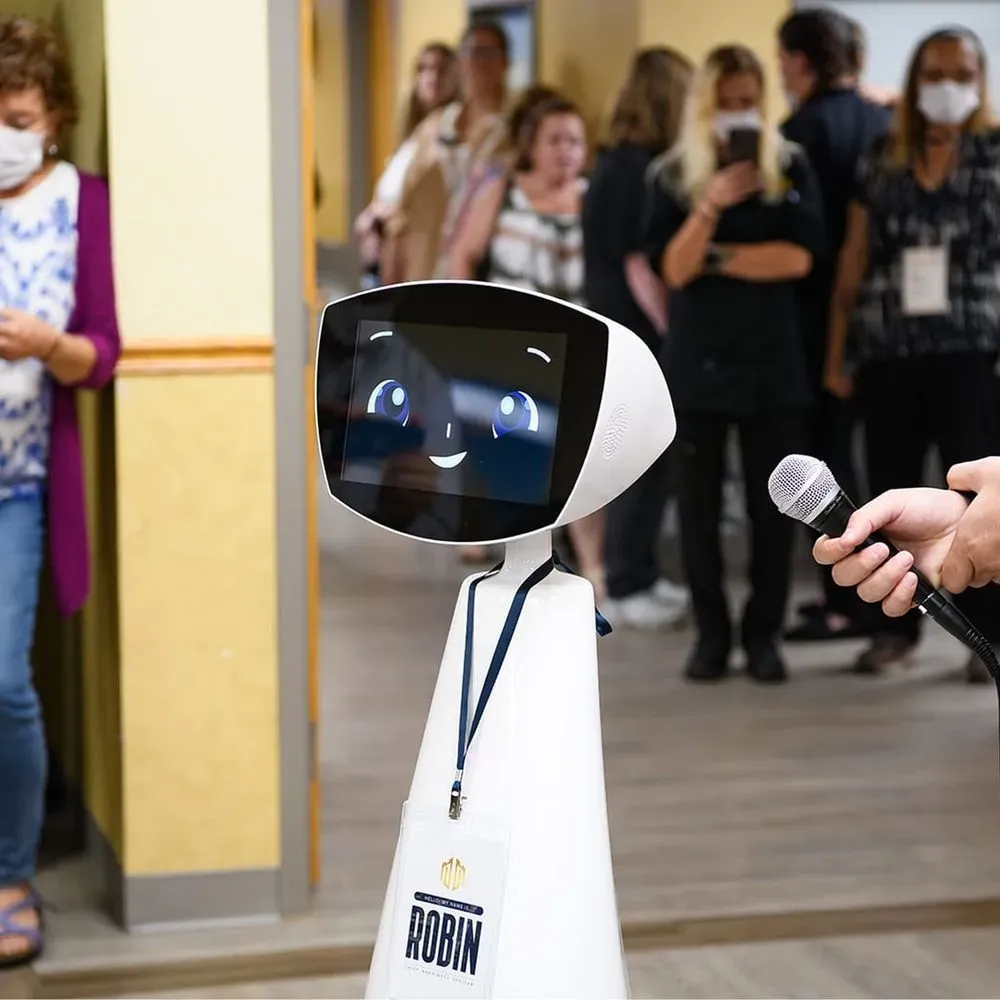 Robin social robot interacting with staff and visitors during a healthcare event.