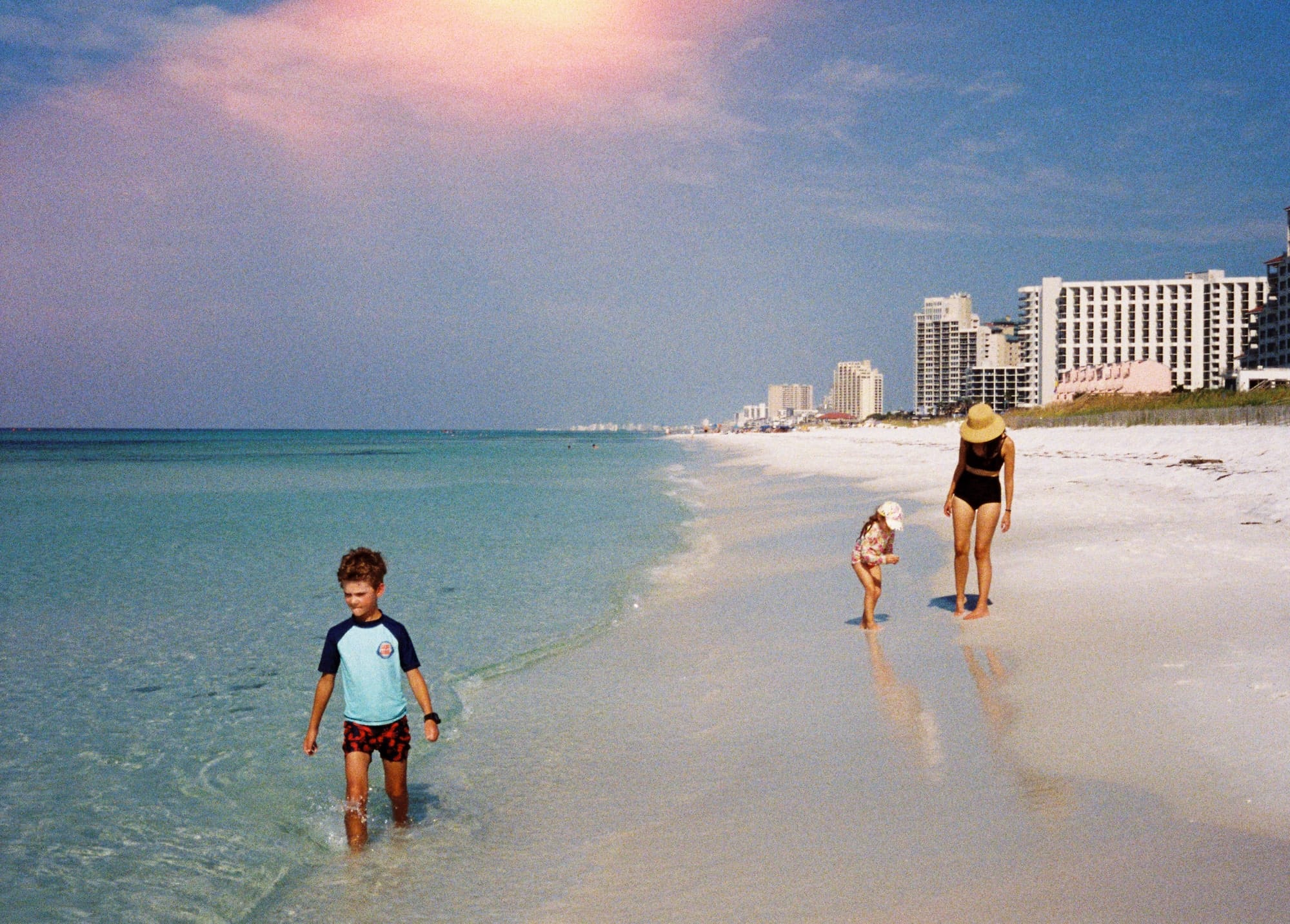 My family on the beach in Miramar Beach, Florida. This photo was taken on an old Olympus Pen half-frame camera. There is a light-leak at the top of the image.