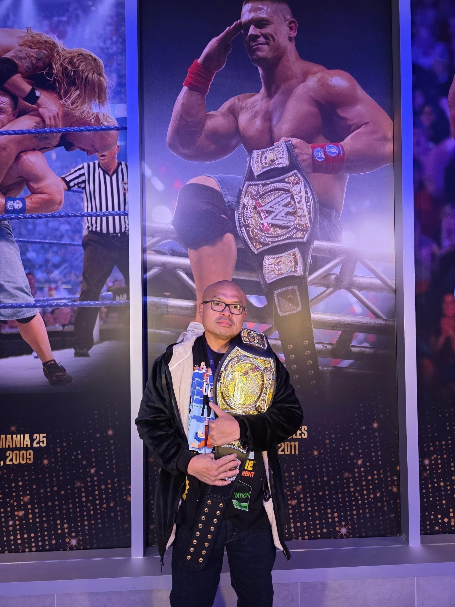 Mike Vuong holds a wrestling belt.