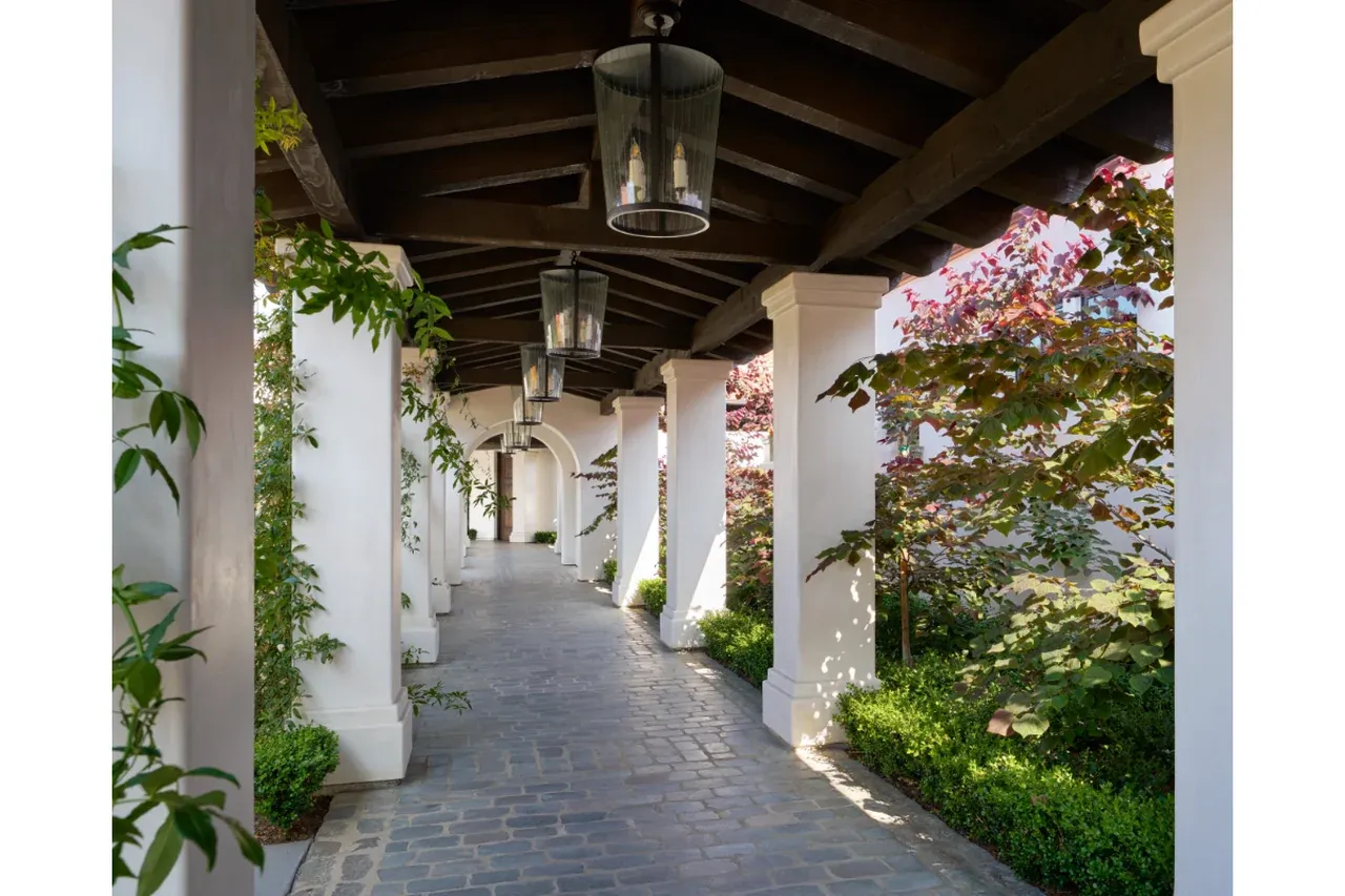 Covered arcade with timber beams and white columns at Bel-Air Country Club’s new MAI clubhouse in Los Angeles