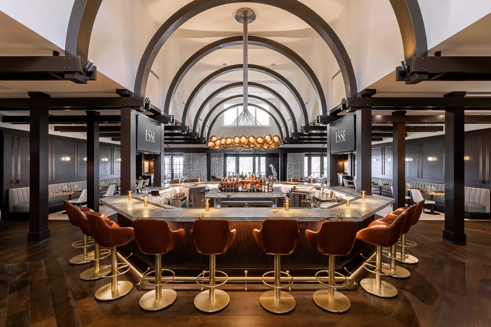 The octagonal bar at ESSĒ beneath vaulted ceilings and dark wood arches at The Landing clubhouse, Reynolds Lake Oconee