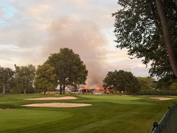 Lochmoor Club clubhouse in Grosse Pointe Woods, Michigan, fully involved in fire, viewed from the golf course