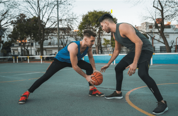 two men playing basketball on a court