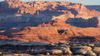 Lost Canyon in the Needles District at sunset, with red rock formations glowing in warm light against rugged desert terrain.
