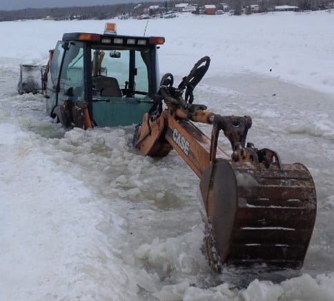 Backhoe goes through ice trying to rescue truck