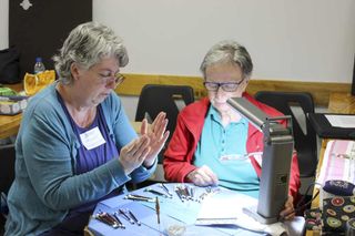 Lacemaker Joyce Poupart, left, helps instruct a fellow lacemaker at the annual Gore Bay International Lace Camp, held last we