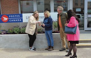 Debby Turner, second from left, shows Canada Post visitors Jenny Waters, left, Graeme Fleming and Melissa Levesque a business