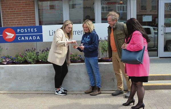Debby Turner, second from left, shows Canada Post visitors Jenny Waters, left, Graeme Fleming and Melissa Levesque a business