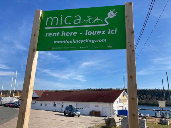 MICA e-bike rental locations (listed on the MICA website) are found near bright green signs like this one at the Gore Bay Mar