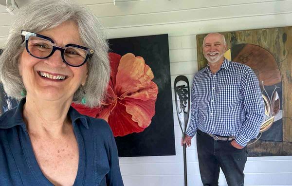Audrey Jolly and Ed Horner are all smiles while posing for a photograph in their art studio. Ms. Jolly is a multi-discipline