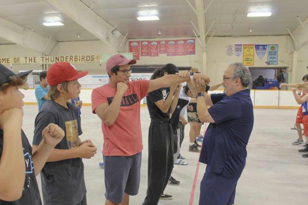 Gordon Apolloni of Top Glove Boxing, far right, instructs a student on how to throw a jab correctly at the Olympic-style boxi