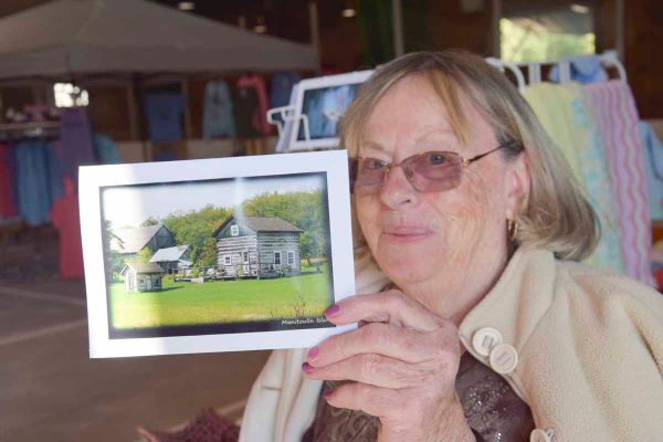 Evelyn Russell-Baehr holds up one of her greeting cards featuring her home.
