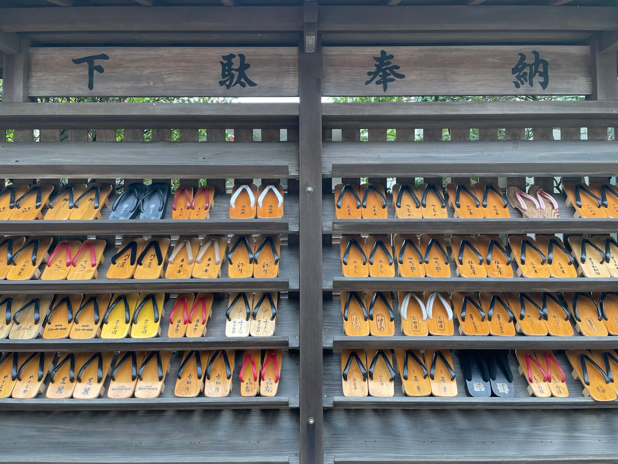 牆上掛著城崎溫泉每一間飯店的木屐，樣式有一點不同，都放在一起很漂亮