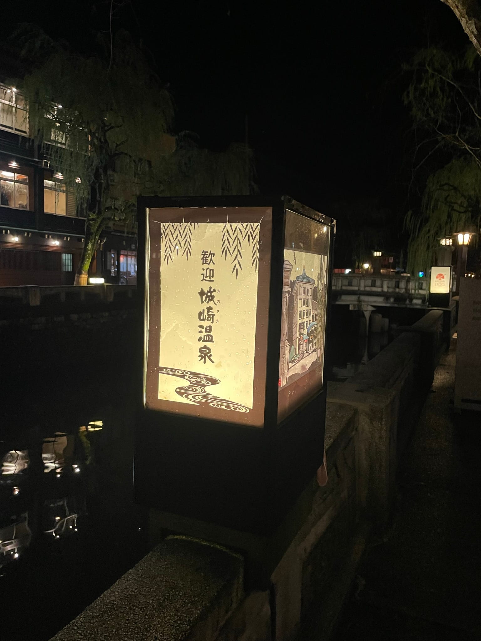 溫泉街溪流旁的燈籠造景，上面印著城崎溫泉