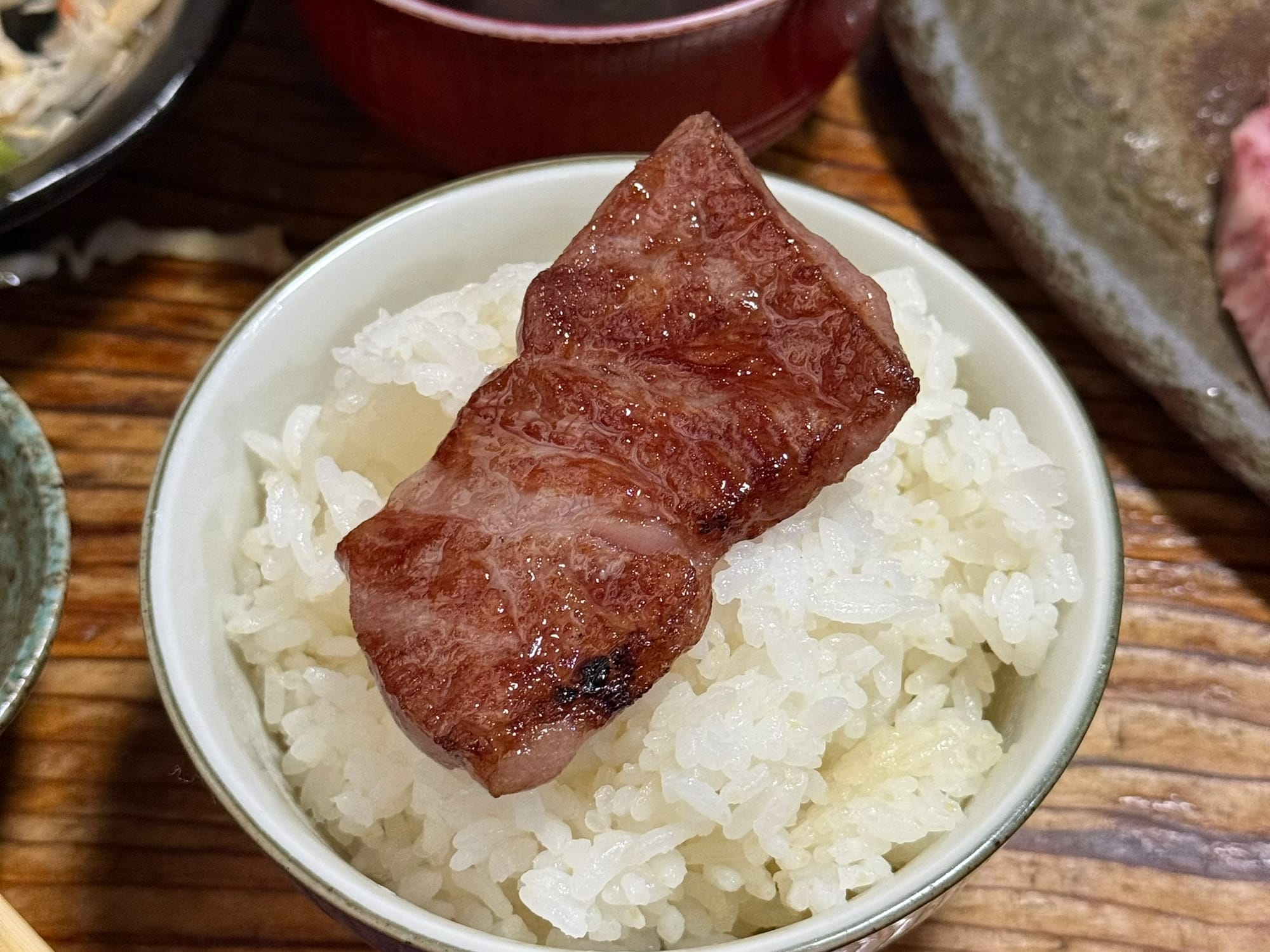在初栄自己動手烤好的高千穗牛肉塊，放在白飯上的特寫照。