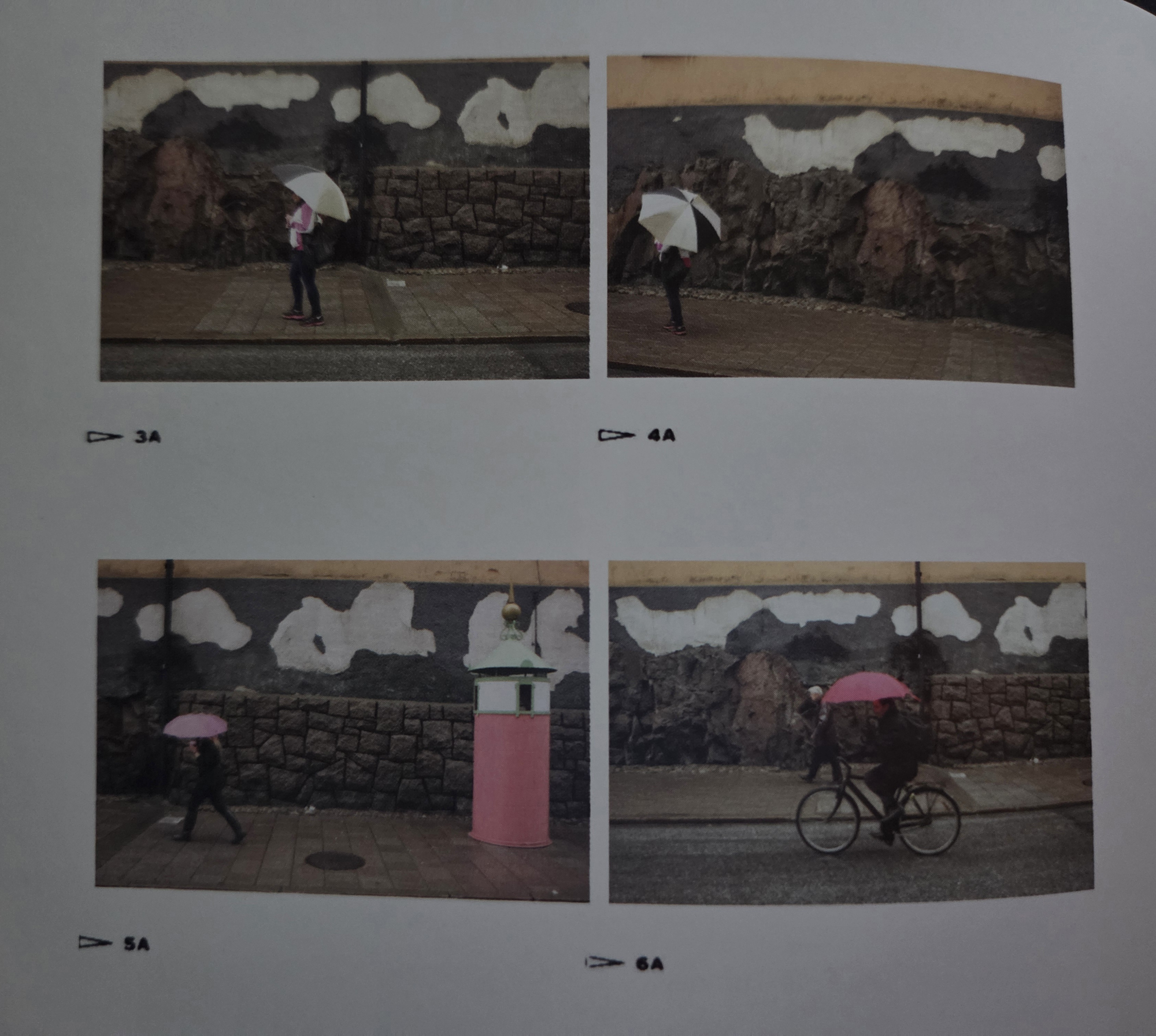 스톡홀름 거리에서 회벽이 벗겨져 구름처럼 보이는 담장 앞을 우산 쓴 행인과 자전거가 지나가는 연속 사진.