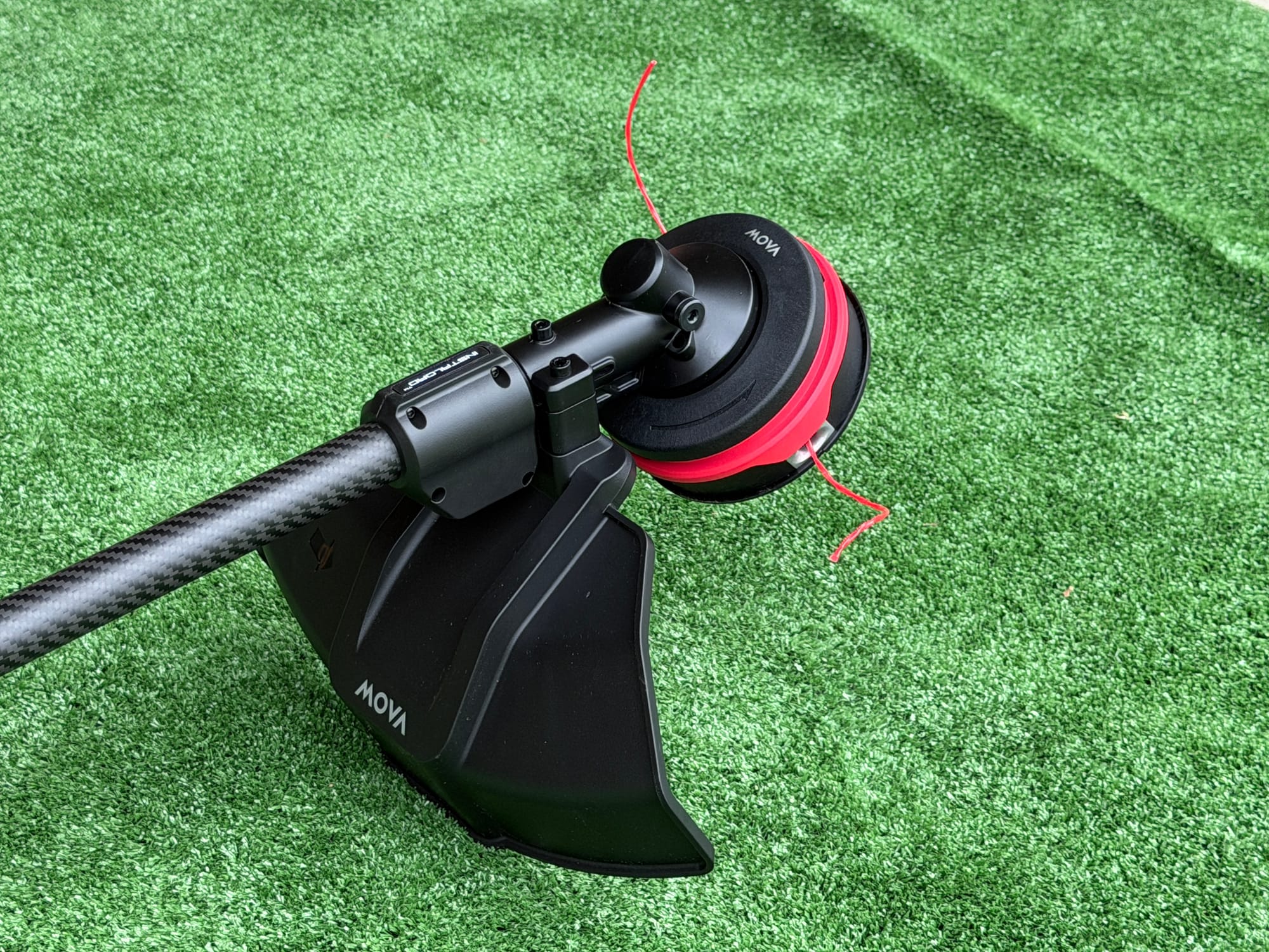 MOVA trimmer's cutting guard, trimmer head, and carbon-fiber shaft laid out before field testing