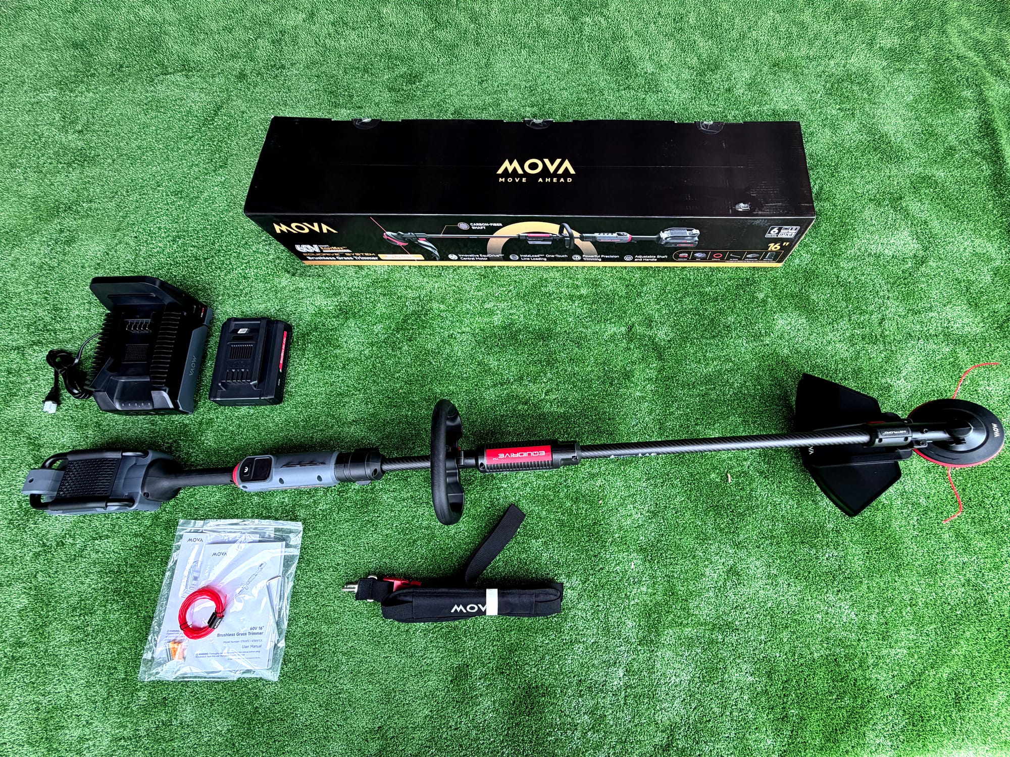 MOVA InstaLoad trimmer kit with battery, charger, trimmer line, and accessories laid out after unboxing
