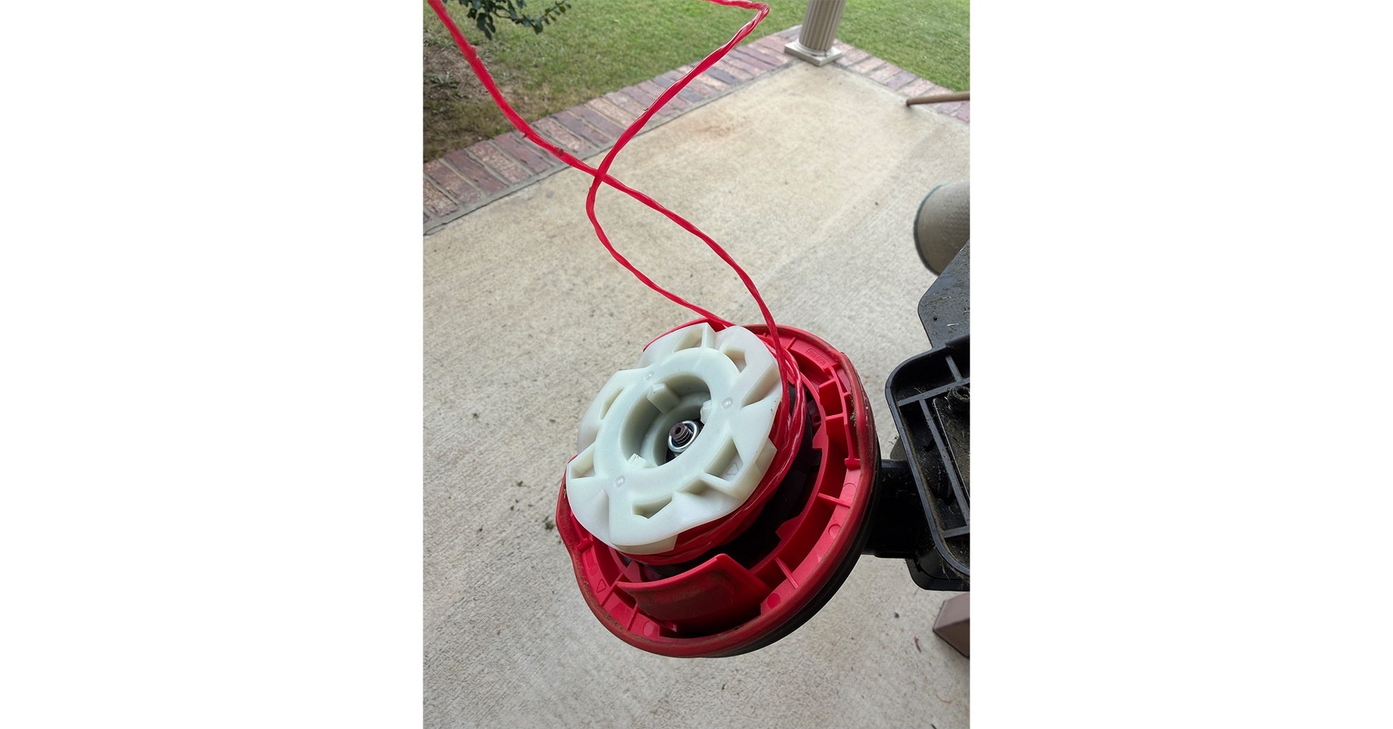 MOVA trimmer's dual-line spool assembly exposed after the cover popped off during use