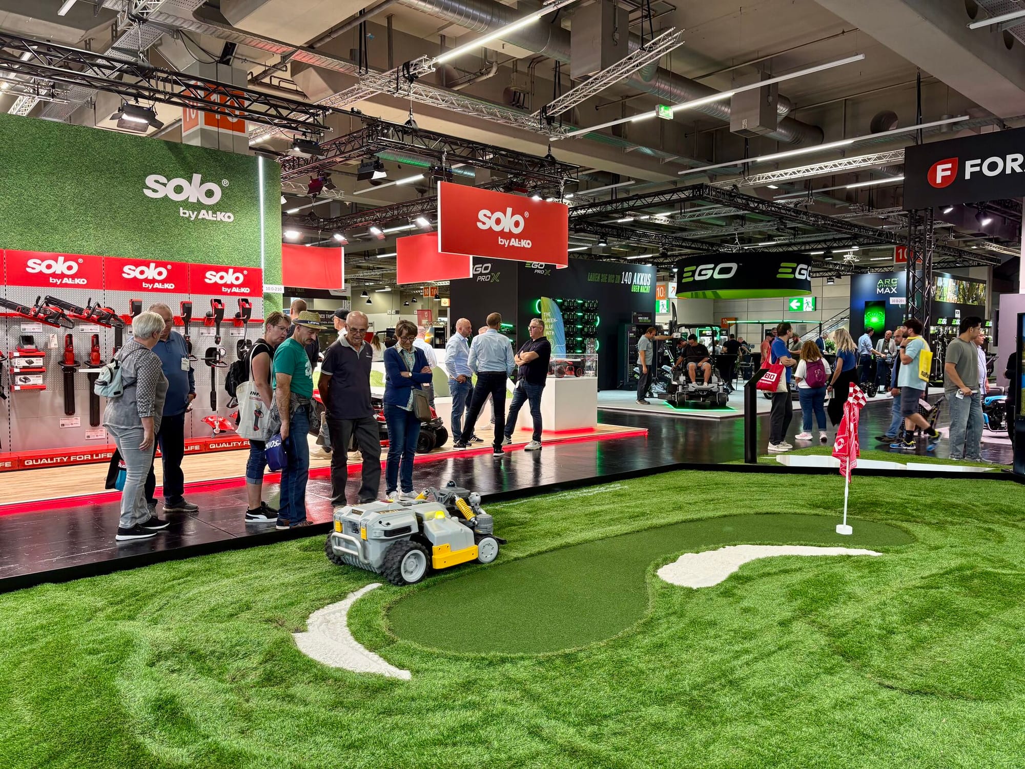 Mammotion Maston commercial robotic mower driving across an artificial putting green at GaLaBau 2026.