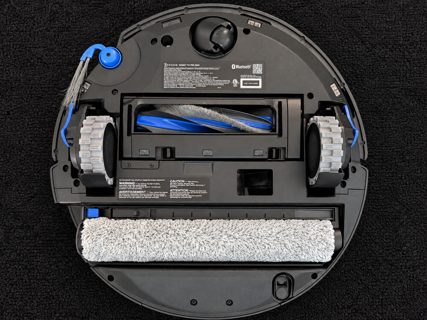 Underside of the Ecovacs Deebot T90 Pro Omni showing the Ozmo Roller 3.0 mop, main brush and wheels.