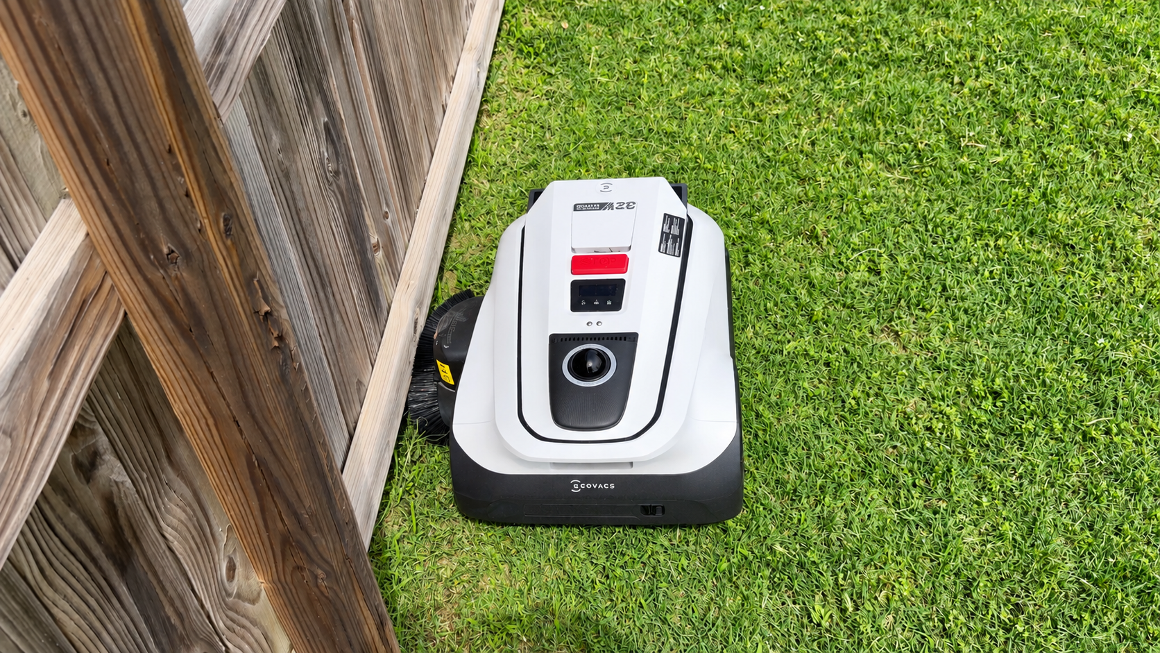 Ecovacs GOAT A2000 LiDAR Pro robotic mower on grass showing its side wheel and TruEdge trimming attachment.