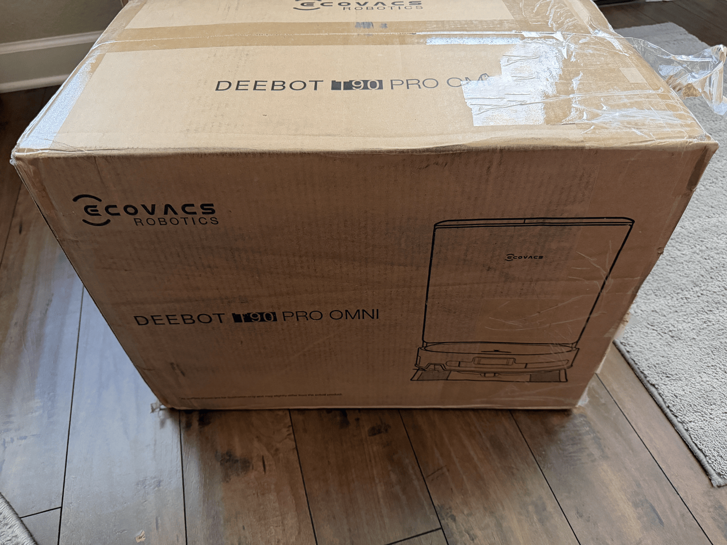 Animated unboxing sequence of the Ecovacs Deebot T90 Pro Omni showing the shipping box, robot vacuum, all-in-one base station, water tanks, cleaning components and included accessories.