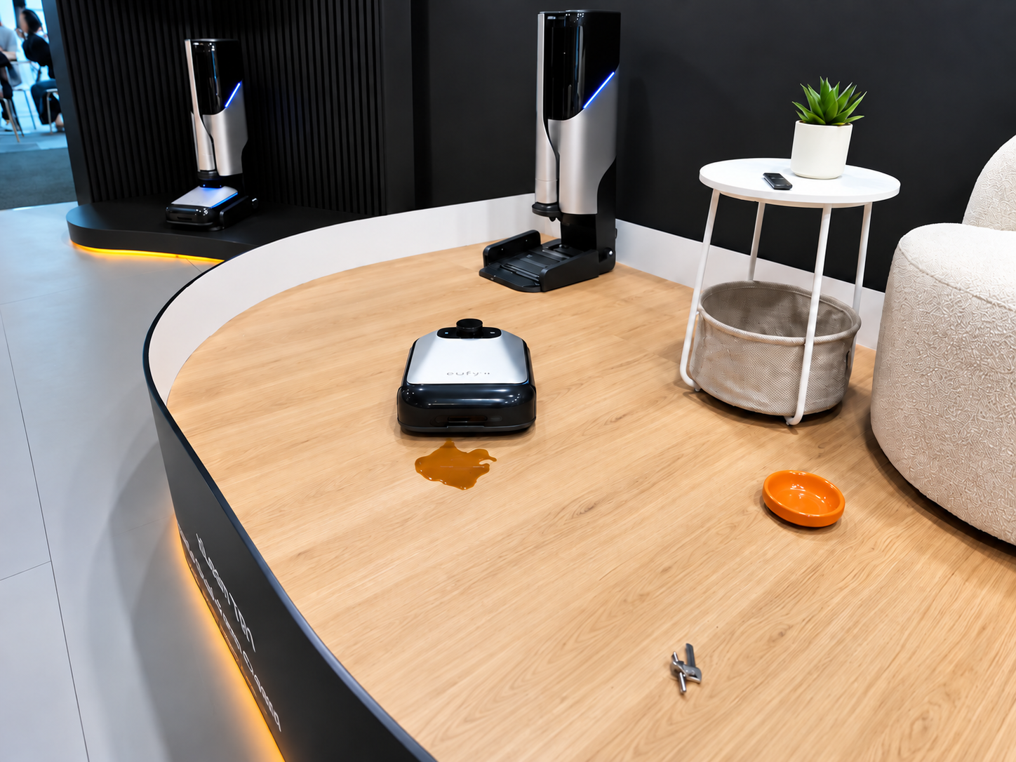 xLean TR1 robot cleaner demonstrated on a wood floor at IFA 2026 with its upright cleaning stations in the background.