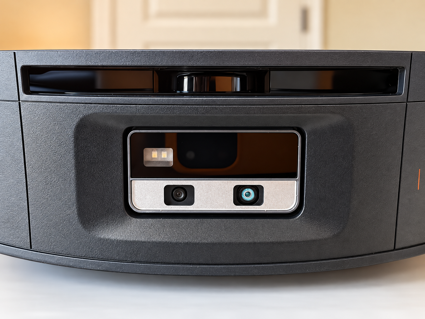 Close-up of the Roborock Saros 20 Flow's front sensor assembly showing its camera lenses, illumination hardware and recessed sensor windows.