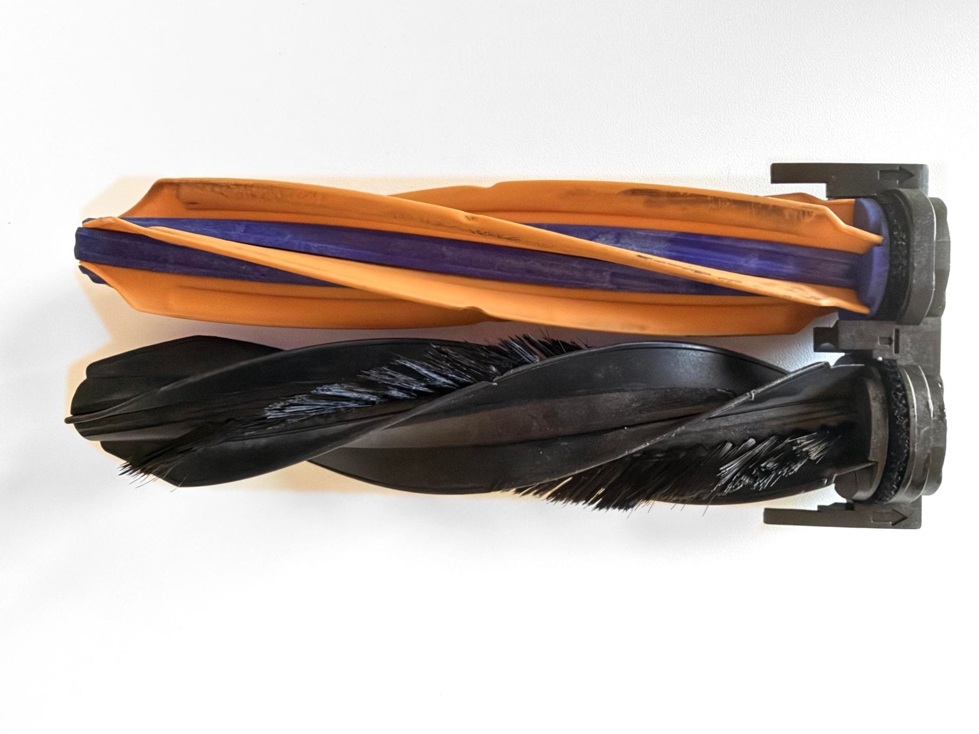 The Dreame X60's dual anti-tangle main rollers, one rubber and one bristle, removed after long-term use