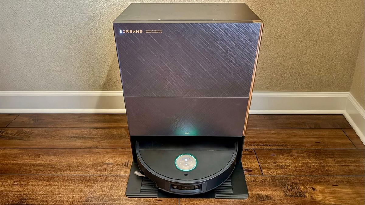 Dreame X60 Max Ultra Complete robot vacuum in its rectangular dock on a wood floor against a beige wall.