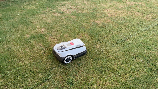 Ecovacs GOAT A2000 LiDAR Pro robotic lawn mower moving across a patchy Bermuda grass yard during testing.
